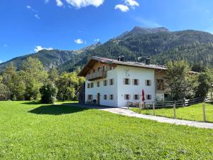 una casa in un campo con montagne sullo sfondo di Hof Ida a Bach