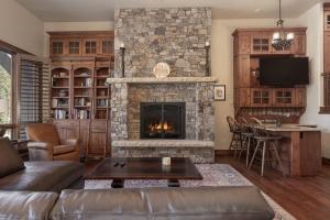 a living room with a stone fireplace at Base Camp at Iron Horse,,, townhouse in Winter Park