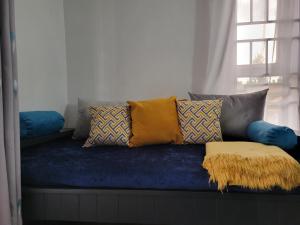 eine blaue Couch mit Kissen darauf mit Fenster in der Unterkunft Rozy homes Jinja in Jinja