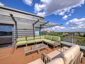 einen Balkon mit Sofas und einem Tisch auf einem Gebäude in der Unterkunft Novotel Kraków Centrum in Krakau