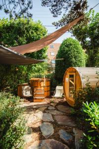 un patio trasero con una casa de madera y una tienda de campaña en Le Castel Cabourg hôtel & SPA- Restaurant La Calypso en Cabourg
