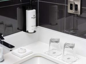 a white counter with two glasses and a bottle at Sofitel London Gatwick in Horley