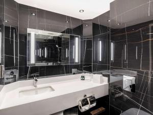 a bathroom with a sink and a mirror at Sofitel London Gatwick in Horley