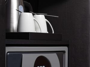 a black box with two mugs on top of a microwave at Sofitel London Gatwick in Horley