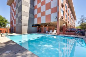 Best Western Los Angeles Worldport Hotel في ويلمنجتون: مسبح امام مبنى