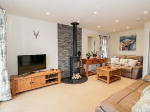 a living room with a television and a couch at Eden Lodge in Newton Stewart