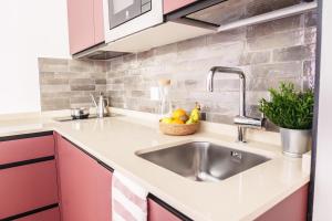 una cucina con lavandino e cesto di frutta di Spirit Apartamentos Valladolid Centro a Valladolid Altre 32 foto