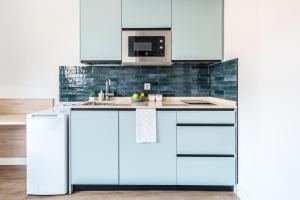 a kitchen with white cabinets and a sink at Spirit Apartamentos Valladolid Centro in Valladolid
