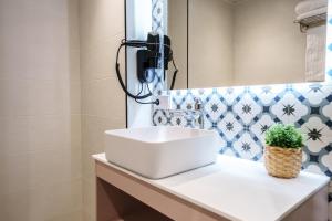 a bathroom with a white sink and a mirror at Spirit Apartamentos Valladolid Centro in Valladolid +33 photos