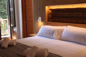 a bedroom with a large white bed with a window at Hotel Saurat in Espot