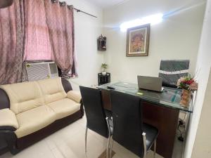 a office with a desk and a couch and a laptop at Aadi's Residency in Gurgaon