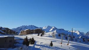 a ski resort with a ski lift in the snow at Appartement Ski aux pieds in L'Alpe-d'Huez