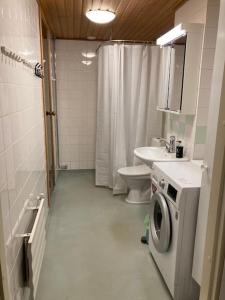 y baño con lavadora y lavamanos. en Kotimaailma - Kalustettu saunallinen asunto kuudelle en Vantaa