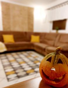 a carved pumpkin sitting on a table in a living room at Lexi Jakuzzis Apartman Balatonboglár in Balatonboglár