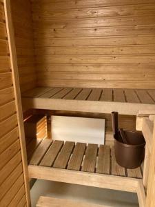 una pequeña sauna de madera con un cubo dentro en Kotimaailma - Kalustettu saunallinen asunto kuudelle en Vantaa