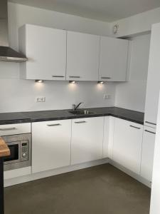 a white kitchen with white cabinets and a sink at Home sweet home Arnhem in Arnhem