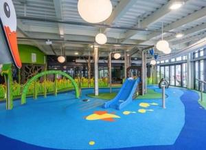 uma área de recreação infantil com escorrega e baloiços em Claire's Retreat, Rudd Lake, Tattershall Lakes em Tattershall