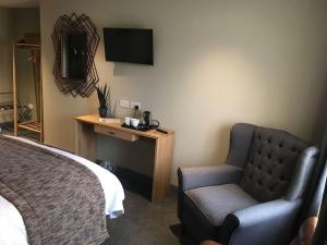 a hotel room with a bed and a chair at The New Hobbit Hotel Rooms in Halifax
