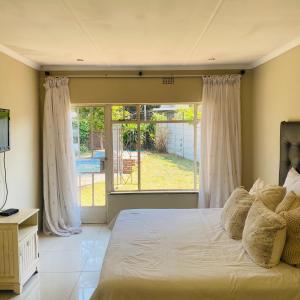 a bedroom with a bed and a large window at Eden homestay in Edenvale