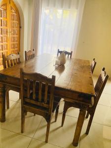a wooden dining room table with chairs at Eden homestay in Edenvale