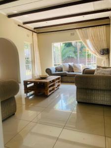 a living room with couches and a coffee table at Eden homestay in Edenvale