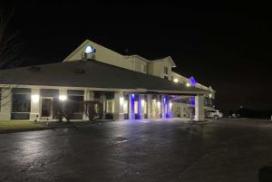 a white building with blue lights in a parking lot at Days Inn by Wyndham Batavia Ohio in Batavia