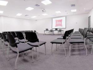 a room with chairs and a screen with a presentation at ibis Apartado in Apartadó