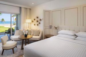 a bedroom with a white bed and a living room at Hyatt Regency Grand Reserve Puerto Rico in Rio Grande