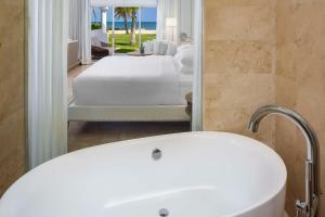 a bathroom with a tub and a bedroom with a bed at Hyatt Regency Grand Reserve Puerto Rico in Rio Grande