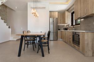 cocina con mesa de madera y sillas en una habitación en Evylio Stone Houses, en Lithakia