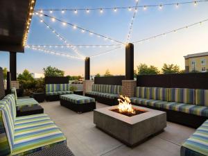 a patio with couches and a fire pit and lights at Home2 Suites Troy, OH in Troy