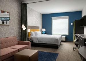 a hotel room with a bed and a couch at Home2 Suites Troy, OH in Troy +21 photos