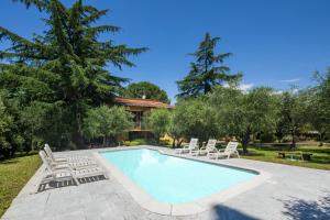 a swimming pool with lounge chairs and a house at Villino Stregatta by VacaVilla in Fucecchio