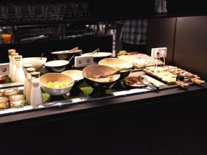 una línea de buffet con muchos tipos diferentes de comida en ibis Lviv Center en Leópolis