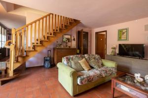 a living room with a couch and a staircase at Villino Stregatta by VacaVilla in Fucecchio