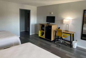 a bedroom with a desk with a television and a bed at Days Inn by Wyndham Gatesville in Gatesville