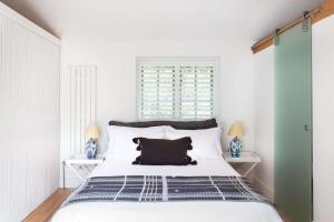 Badgers Cottage في Fittleworth: غرفة نوم عليها سرير ومخدة سوداء