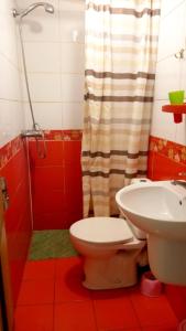 リヴィウにあるCoffee Hostelの赤いバスルーム(トイレ、洗面台付)