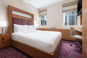 a large bed in a hotel room with a desk and window at Hotel 57 by LuxUrban in New York