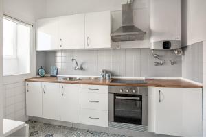 a kitchen with white cabinets and a sink at ALTIDO Striking flat in Benfica in Lisbon