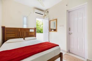 a bedroom with a bed with a red blanket on it at Stayhome Suites in Bengaluru