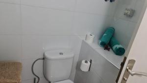a white bathroom with a toilet and a green towel at Aquarius Loft in Callao Salvaje