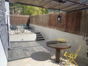 patio con tavolo, sedie e recinzione di Appartement au calme et belle terrasse a Peyroules