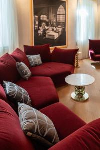 ヴェローナにあるPalazzo Reggiani - Leonardo Da Vinciのリビングルーム(赤いソファ、テーブル付)