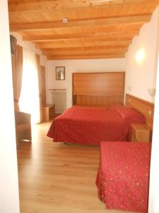 - une chambre avec deux lits et un plafond en bois dans l'établissement Hotel Montebaldina, à San Zeno di Montagna
