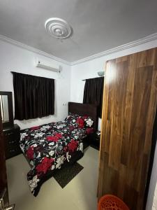 a bedroom with a bed with a floral comforter at Cozy one bedroom, Lekki-ikate in Lagos
