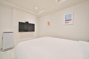 a white room with a bed and a flat screen tv at Hotel Yeogiuhtte Gumi Indong 2 in Gumi