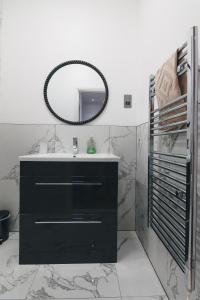 a bathroom with a black vanity and a mirror at Modern apartment in Aberdeen City Centre, Guild street, free WiFi in Aberdeen