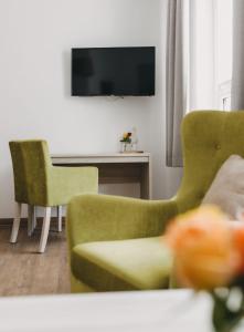 uma sala de estar com duas cadeiras e uma televisão em Hotel am Stadtpark Nordhausen em Nordhausen