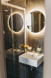 uma casa de banho com um lavatório e 2 espelhos em Hotel am Stadtpark Nordhausen em Nordhausen